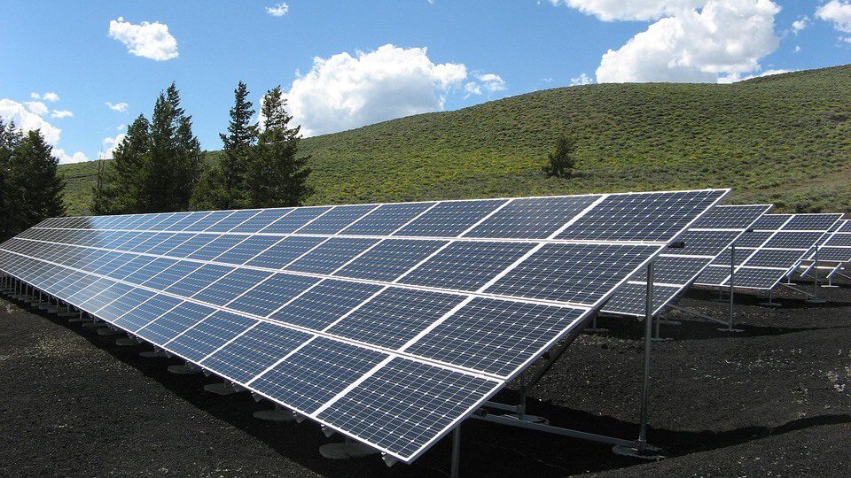 A large solar panel sitting in the middle of a field.